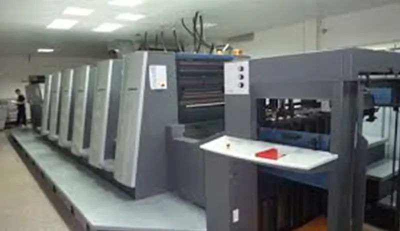 A commercial digital printer producing a sheet of colorful cosmetic box designs