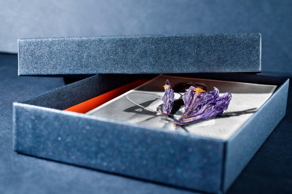 An elegant unboxing scene, with hands carefully opening a beautifully crafted luxury box, revealing a product nestled in custom-fit inserts.