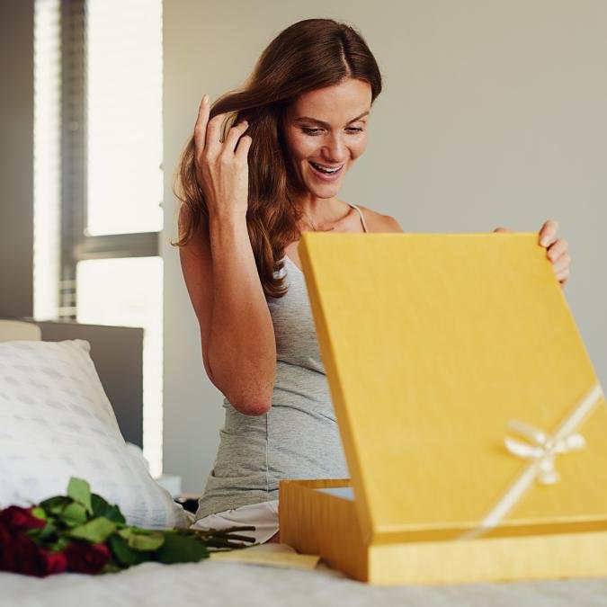 A customer smiling as they unbox a beautifully packaged product