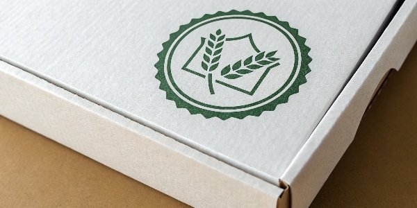 A close-up shot of a food-grade certification symbol on a paper box.