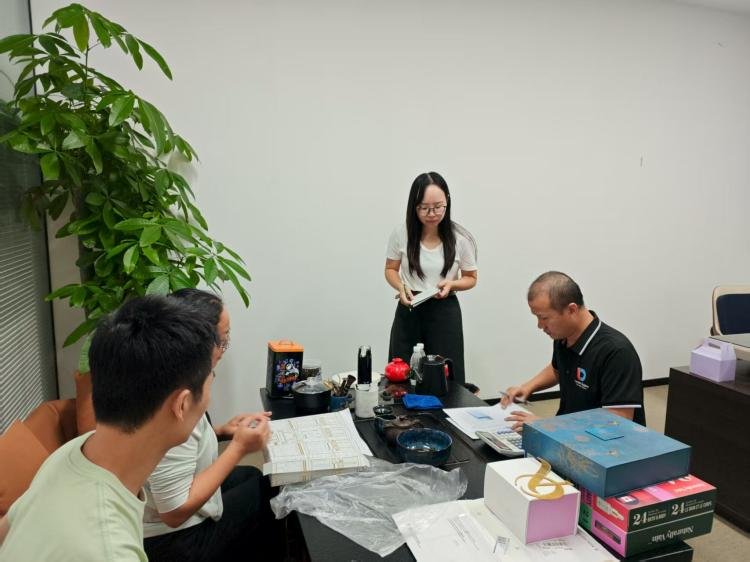 Stages of Custom Packaging Production A designer reviewing a packaging prototype on a desk.