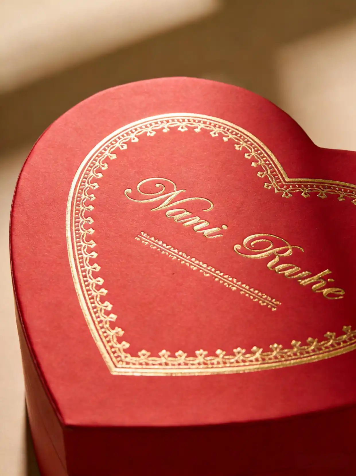 Close-up of a red heart box with gold foil stamping and embossing